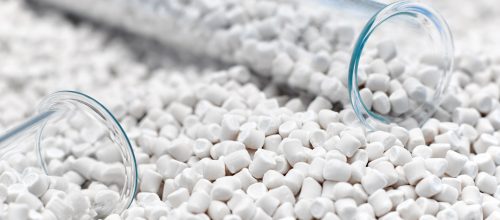 A closeup of a granule of plastic polymers or chalk polymers on a blue background.