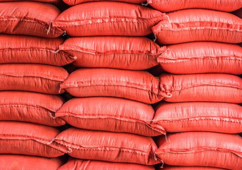 Piles of sacks with agricultural products in storehouse